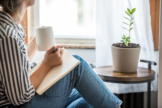  woman sitting and writing with pen and paper