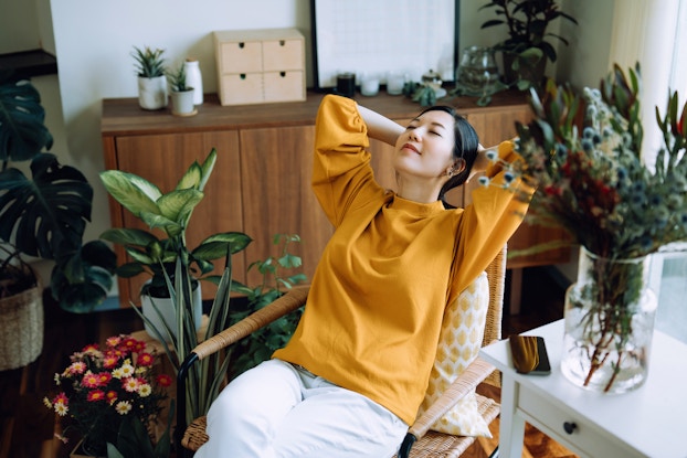  Woman leaning back in her chair smiling and relaxing with her eyes closed.