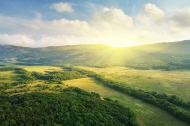  Scenic aerial view of a sunrise over a green pasture. 