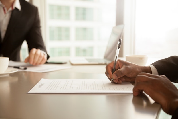 person filling out papers at a desk