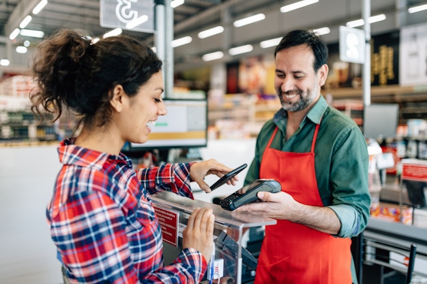 Woman paying with her phone at a store.