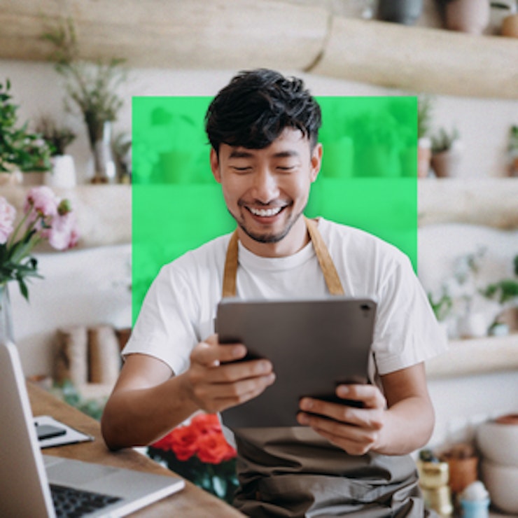 a man smiling while holding a tablet