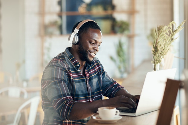 man wearing headset working on laptop