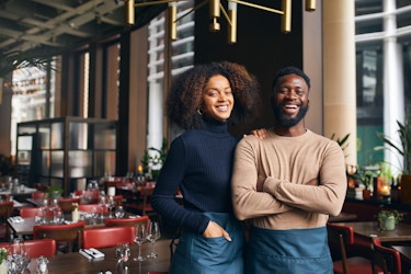  Two minority business owners inside their restaurant. 