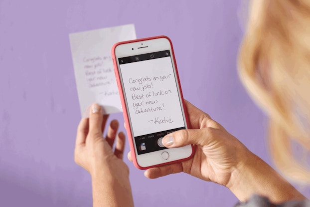 Person writing a Hallmark "Sign and Send" card on their smartphone.