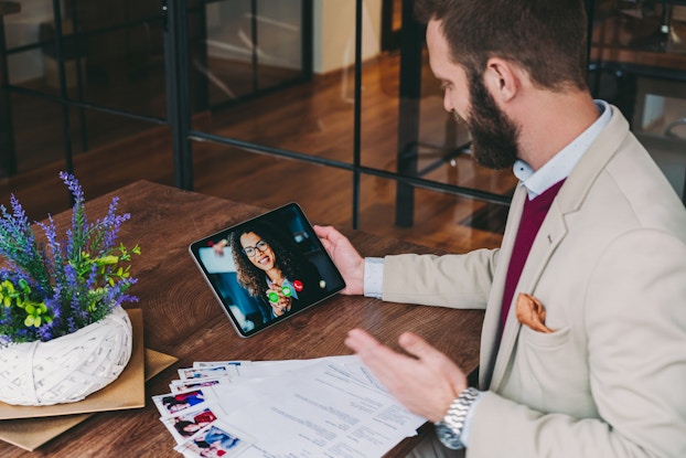  human resources manager interviewing a candidate in a video chat on a tablet