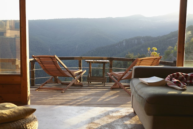  Two chairs on a balcony overlooking the mountains.