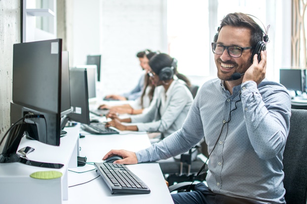 man at work on headset and computer