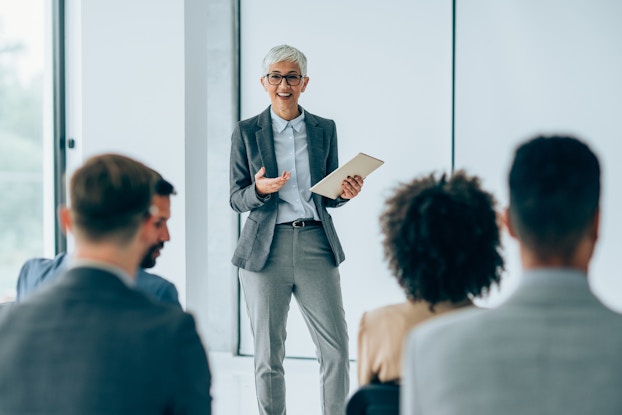 Professional person presenting to a team of colleagues.