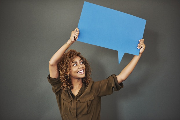 woman standing holding speech bubble