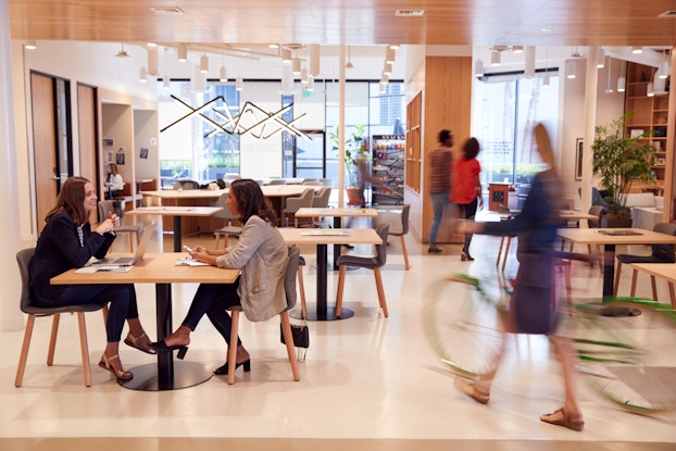 Professionals meeting in a modern, open workspace.