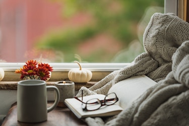  cozy nook near window with book, reading glasses, coffee mug and fall decor 