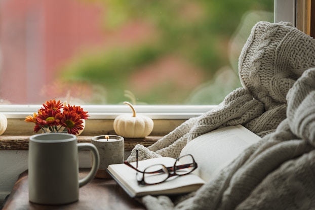  cozy nook near window with book, reading glasses, coffee mug and fall decor