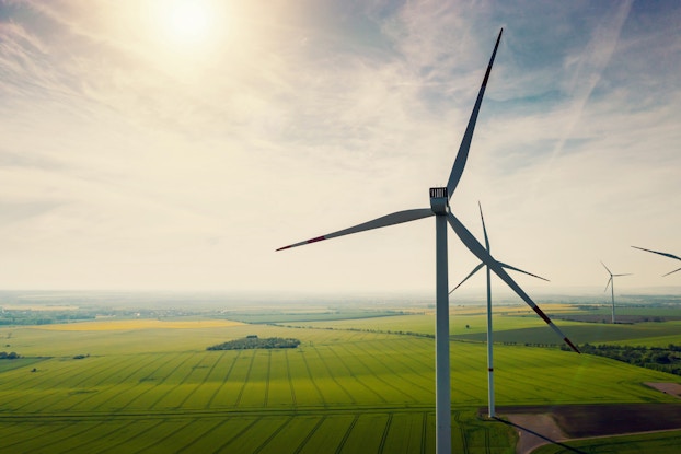 Wind turbines in a green field.