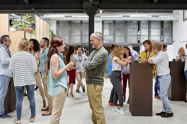 Group of people dressed casually networking in a large room.
