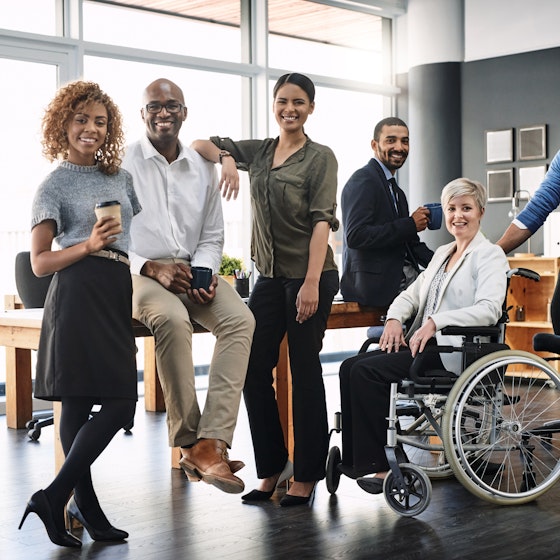 A diverse team of employees standing in a conference room.