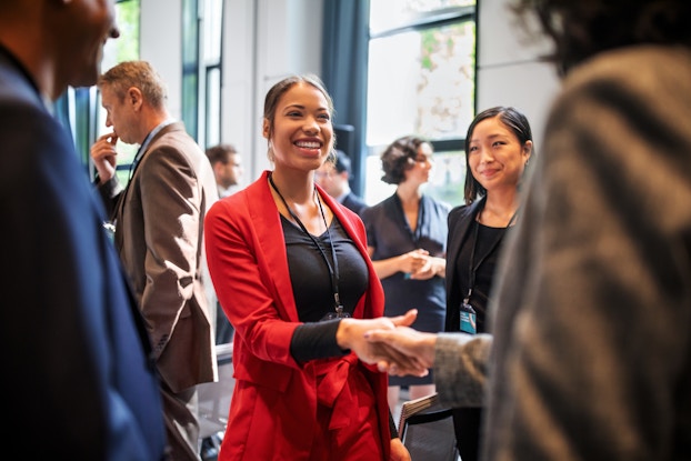 Group of professionals at a meeting shaking hands.