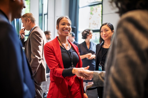  Group of professionals at a meeting shaking hands.