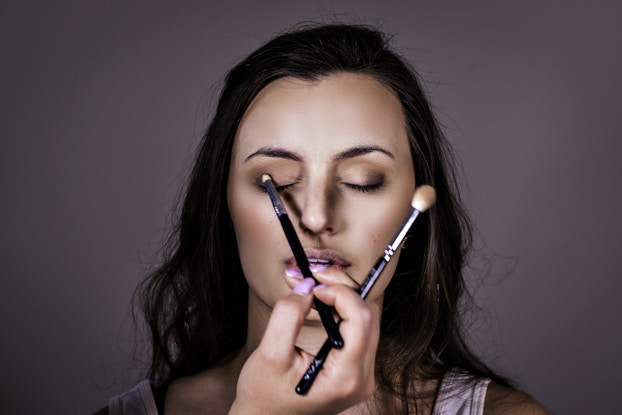 girl getting professional makeup done