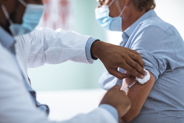 Person getting a vaccination from a doctor.
