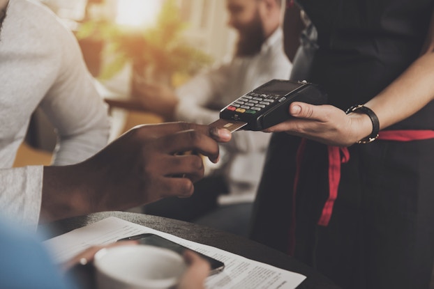  man paying with credit card wirelessly