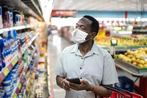 man shopping in supermarket with mask on