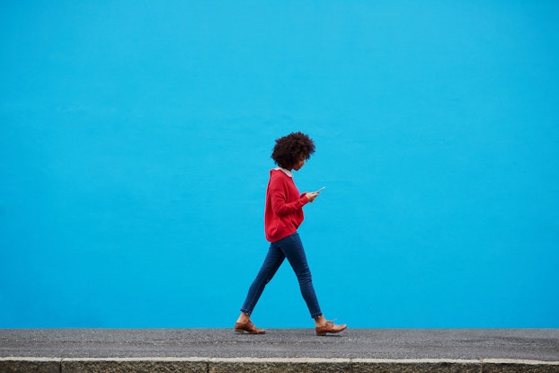 woman walking while on smartphone