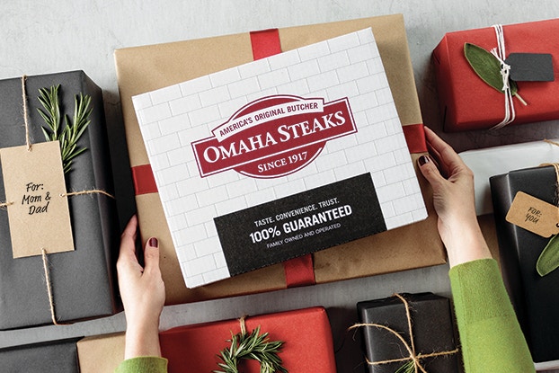 Omaha Steaks gift package on a table among other wrapped parcels.
