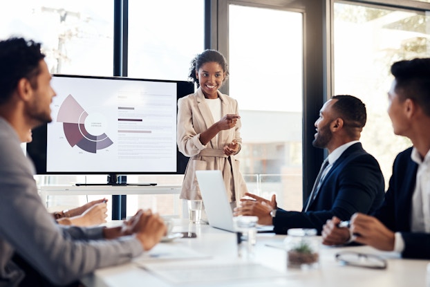  woman giving presentation to coworkers