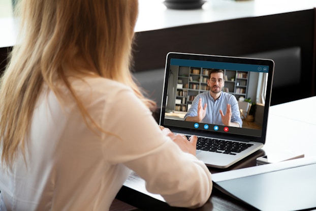 Two colleagues conduct a performance review on video chat.