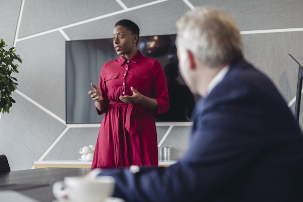 Professional woman presenting to a room of investors.