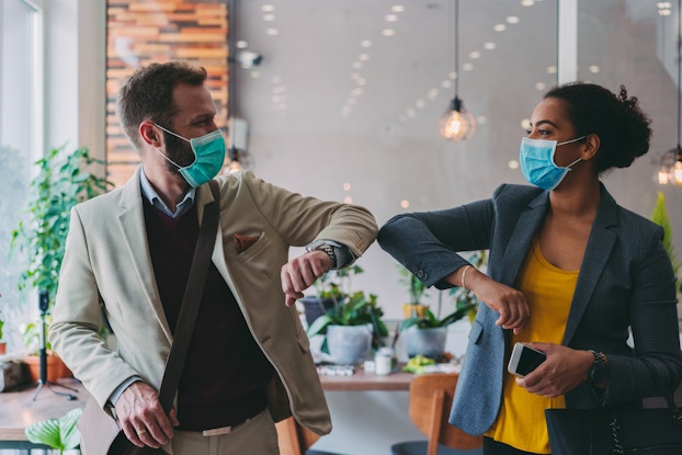 two businesspeople bumping elbows