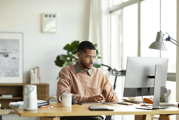  Man working in an office focused on his computer.