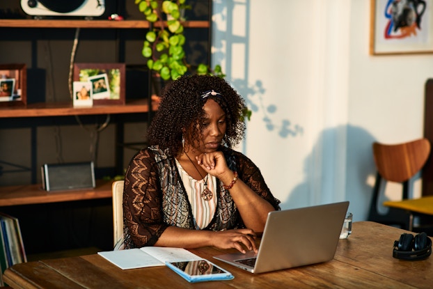 Woman working on her laptop in a home office.