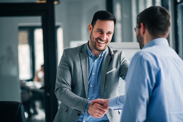  two men shaking hands at work