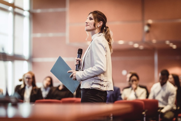 woman speaking in front of audience