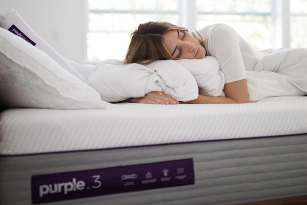  woman sleeping on purple mattress