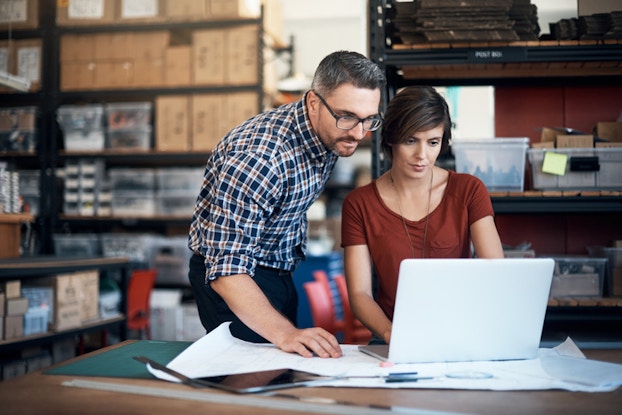 man and woman working on computer at work