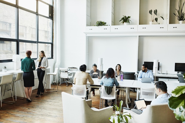  Group of workers inside a bright, open coworking office space.