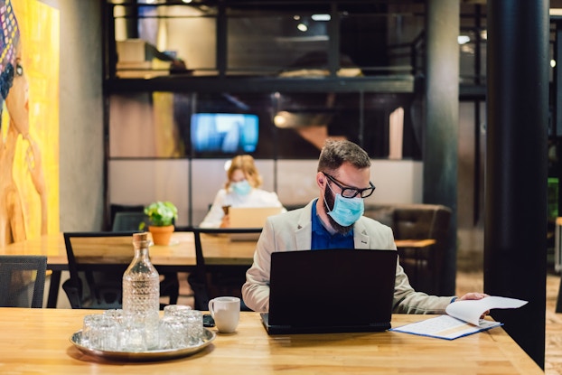  two employees working in office with masks on