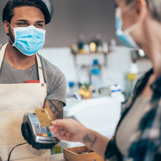 customer paying employee with credit card while wearing masks