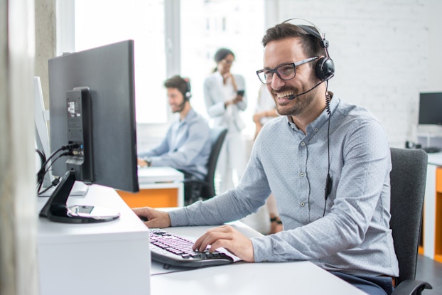 male employee on headset and computer