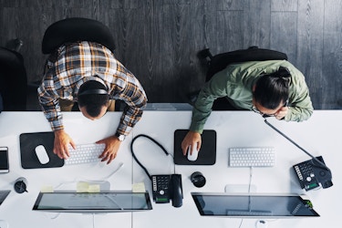 top view of two employees working on desktops