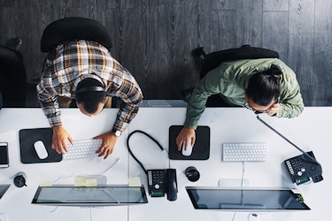  top view of two employees working on desktops 