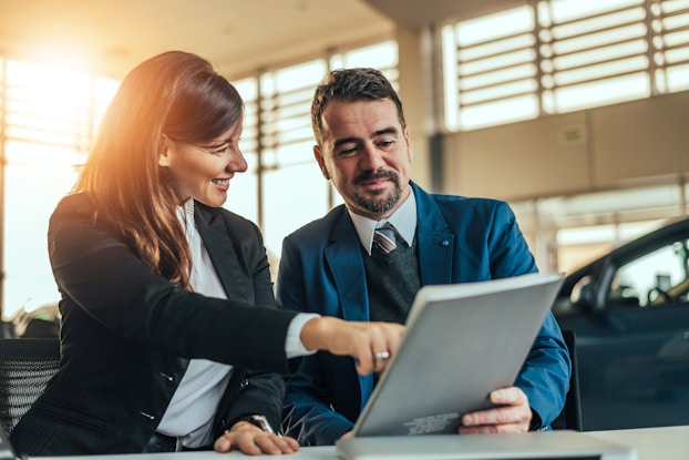two professionals in a meeting going over paperwork
