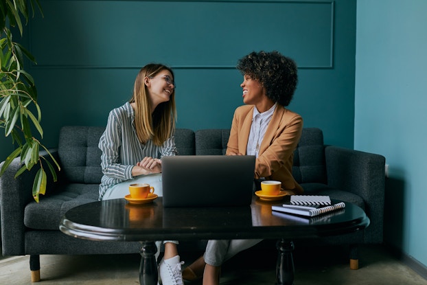  Person meeting with an HR representative in a cool office sitting on a couch.