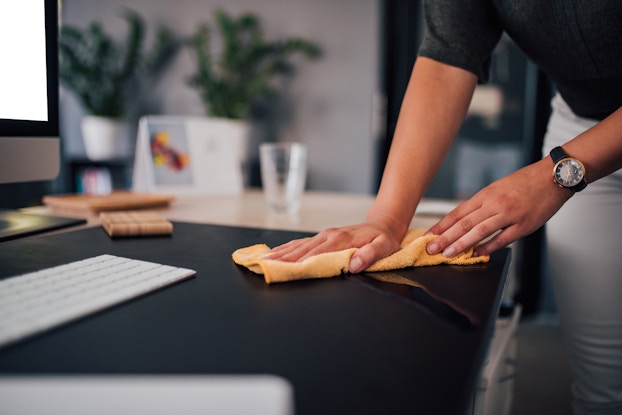  woman cleaning office desk