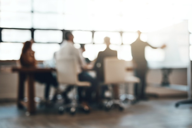 blurred image of a group of employees in a meeting