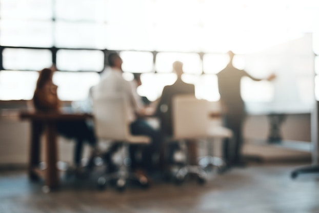  blurred image of a group of employees in a meeting