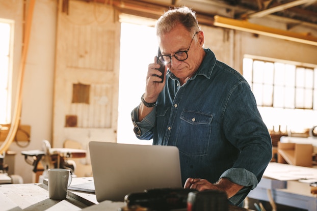 Man in demin shirt working on laptop